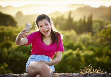 Teenager-Mädchen macht Gesicht für Selfie auf Smartphone, Mallorca, Spanien - CUF38107
