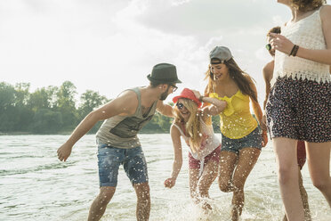 Group of young friends running in lake - CUF38132