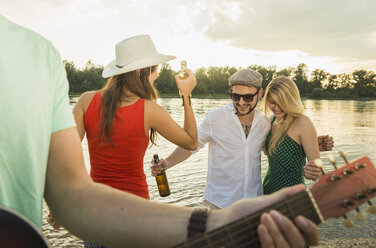 Gruppe von Freunden mit Bier, Gitarre im Vordergrund - CUF38138