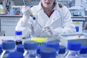 Cancer research laboratory, scientist working with cells kept in ice after storage in sub zero temperatures in a liquid nitrogen cryopreservation chamber - CUF38186