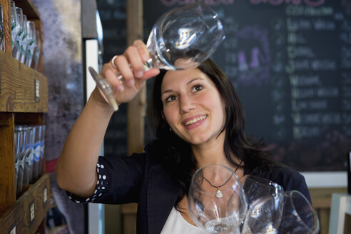 Frau überprüft Weingläser in einem Geschäft - CUF38217