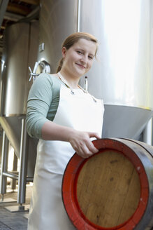 Young woman carrying beer barrel - CUF38227