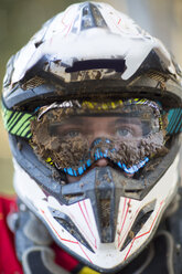 Nahaufnahme eines männlichen Motocross-Rennfahrers mit schlammigem Helm und Schutzbrille - CUF38539