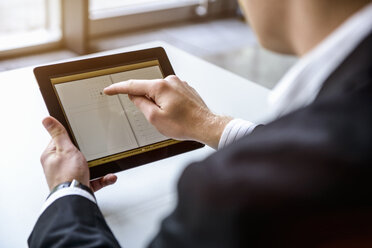 Close up of young man in office using touchscreen on digital tablet - ISF15429