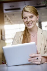 Portrait of young businesswoman with digital tablet in office - ISF15431
