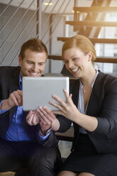 Geschäftsmann und Frau mit digitalem Tablet im Treppenhaus eines Büros - ISF15474