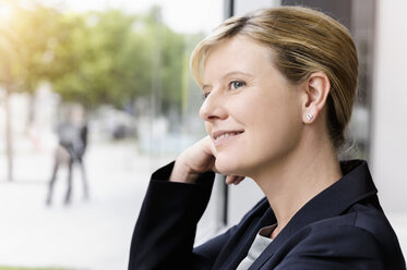 Mature businesswoman gazing out of office window - ISF15496