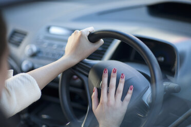 Cropped view of young businesswoman's hands pressing car horn - ISF15539