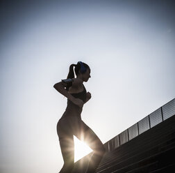 Young woman running up steps - ISF15563