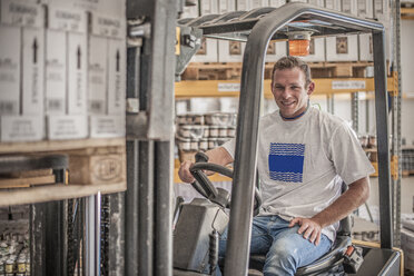 Portrait of young male forklift driver in factory warehouse - ISF15589
