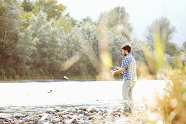 Young man fishing in river, Premosello, Verbania, Piemonte, Italy - CUF38645