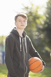 Portrait of young man holding basketball - CUF38673