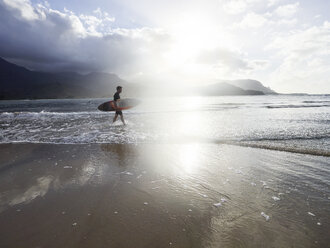 USA, Hawaii, Kauai, Hanalei Bay Resort, man on the beach with surfboard - CVF00924