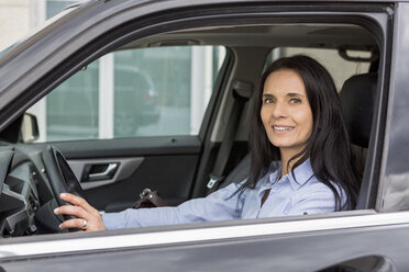 Porträt einer lächelnden Frau am Steuer eines Autos - JUNF01079