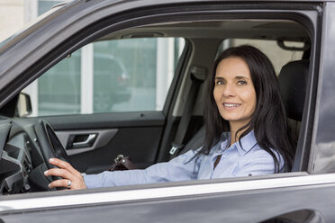 Portrait of smiling woman driving car - JUNF01079
