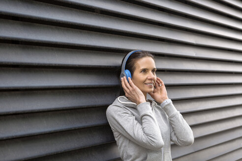 Frau hört Musik mit Kopfhörern - JUNF01080
