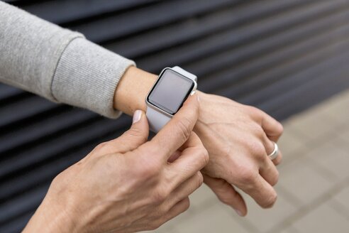 Hand einer Frau, die die Einstellungen einer Smartwatch vornimmt, Nahaufnahme - JUNF01081