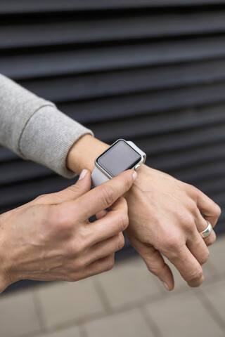 Woman's hand adjusting settings of smartwatch, close-up stock photo