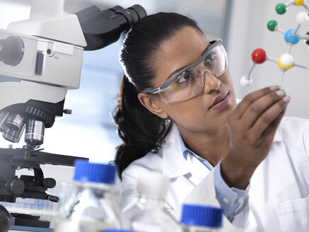 Biotechnologie-Forschung, Wissenschaftlerin, die im Labor eine chemische Formel mit Hilfe eines molekularen Kugel-Stab-Modells untersucht - ABRF00163