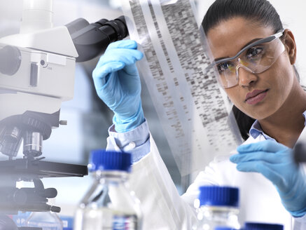 Genetic Research, female scientist holding a foil with genetic code, the genetic make-up - ABRF00177