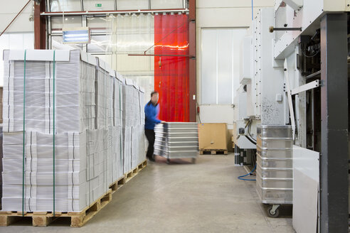 Fabrikarbeiter transportieren Container mit Pappe - CUF38745