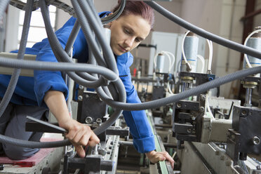 Fabrikarbeiter bei der Arbeit an Maschinen - CUF38754