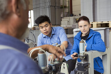 Fabrikarbeiter bei der Arbeit an Maschinen - CUF38757