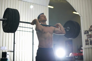 Mann hebt Langhantel im Fitnessstudio - CUF38784