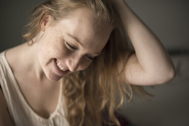Porträt einer jungen Frau mit Sommersprossen, die lacht - CUF38804
