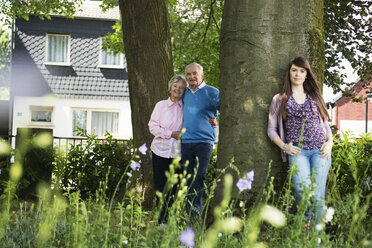 Großeltern und Enkelin stehen am Baum - CUF38834