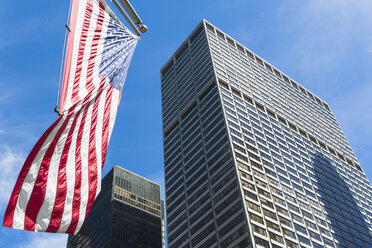 Niedrige Winkelansicht von Wolkenkratzern und amerikanischer Flagge im Finanzviertel, Manhattan, New York, USA - ISF15739