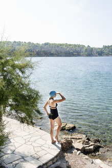 Rückansicht einer jungen Frau im Badeanzug, die aufs Meer hinausblickt, Milna, Brac, Kroatien - ISF15789