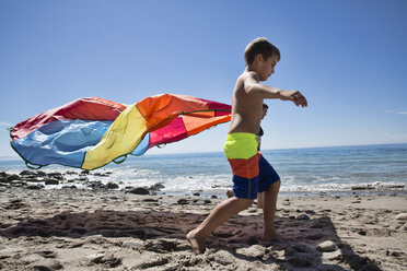 Mutter und Sohn laufen mit buntem Stoff am Strand, County Park, Los Angeles, Kalifornien, USA - ISF15827