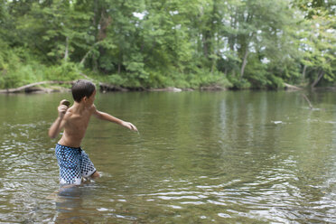 Teenage boy skimming stones in river, Canton, North Carolina, USA - ISF15845