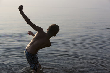 Teenage boy losing balance in Lake Superior, Au Train Bay, Michigan, USA - ISF15850