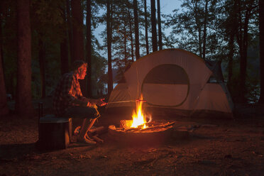 Mann kocht am Lagerfeuer im Wald bei Nacht, Arkansas, USA - ISF15860