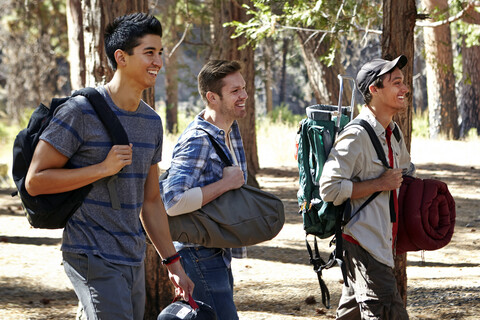 Drei junge männliche Camper gehen durch den Wald, Los Angeles, Kalifornien, USA, lizenzfreies Stockfoto