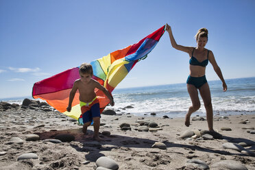 Ältere Frau und Sohn laufen mit mehrfarbigem Textil am Strand, County Park, Los Angeles, Kalifornien, USA - ISF15963