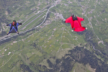 Zwei Männer fliegen in Wingsuits über Felder - ISF15992