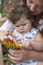 Mutter und Tochter betrachten gemeinsam eine Blume - ISF15999
