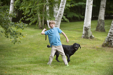 Young boy outdoors, throwing stick for dog - ISF16070