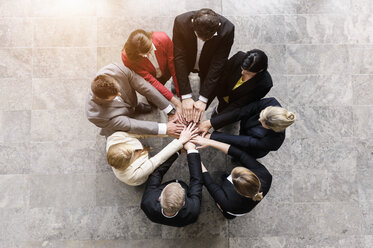 Overhead view of businessmen and women in circle with hands together - ISF16169