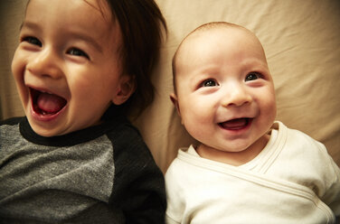 Overhead view of male toddler and baby brother laughing - ISF16190