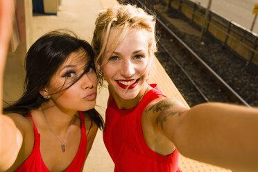 Zwei junge Frauen machen ein Selfie auf dem Bahnsteig - ISF16251