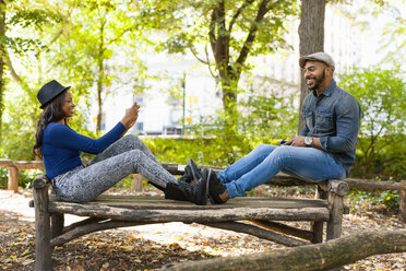 Ehepaar beim Fotografieren auf einer Bank, Central Park, New York, USA - ISF16256