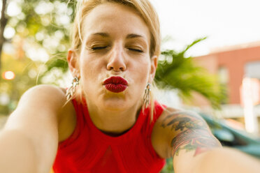 Porträt einer jungen Frau in Rot, die für ein Selfie posiert - ISF16265
