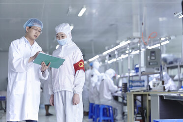 Arbeiter diskutieren in einer E-Zigarettenfabrik - ISF16281