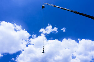 Griechenland, Kreta, Bungee Jumping, Mann springt Bungee vor Wolken - BEF00178