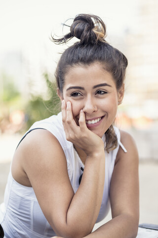 Porträt einer lächelnden jungen Frau mit Dutt, lizenzfreies Stockfoto