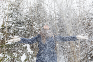 Glückliche Frau, die mit Schnee wirft und Spaß hat - WPEF00617